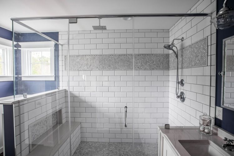 A bathroom with a walk in shower and a sink.