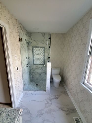 A bathroom with a toilet and a walk in shower.
