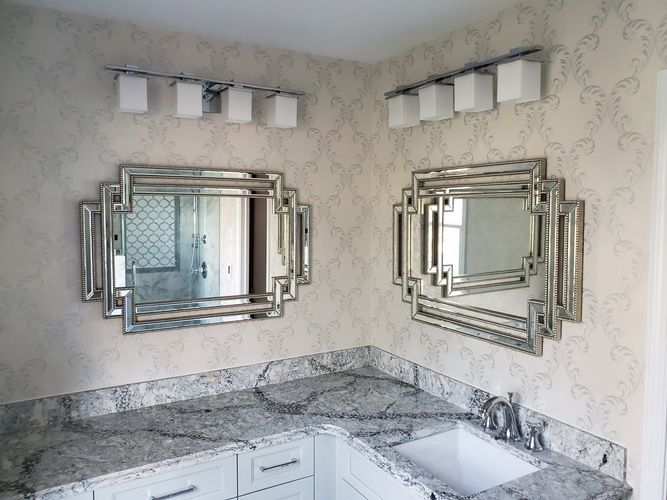 A bathroom with two mirrors and a sink.