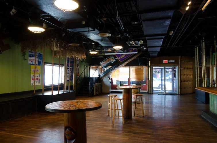 An empty room with tables and stools in it