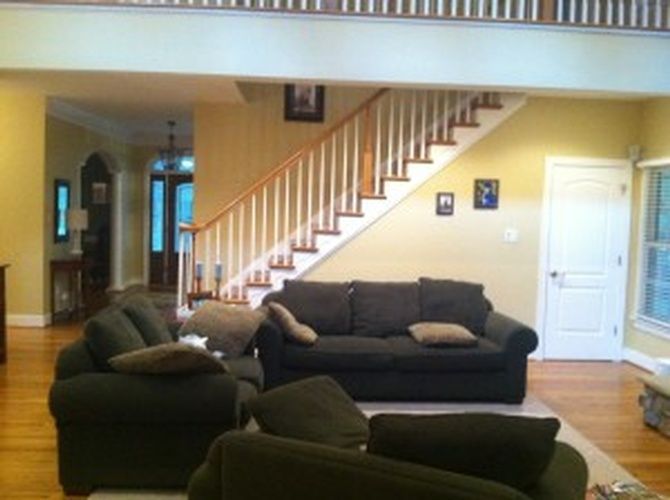 A living room with a staircase leading up to the second floor