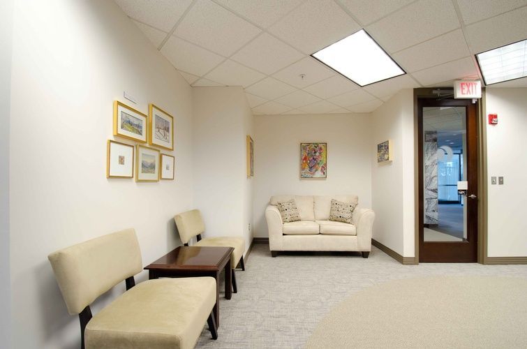 A waiting room with a couch and chairs in it