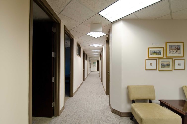 A long hallway with a chair and pictures on the wall