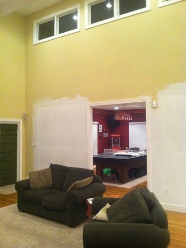 A living room with a couch and chairs and a pool table