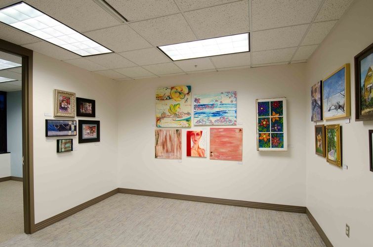 A room with a lot of paintings on the wall