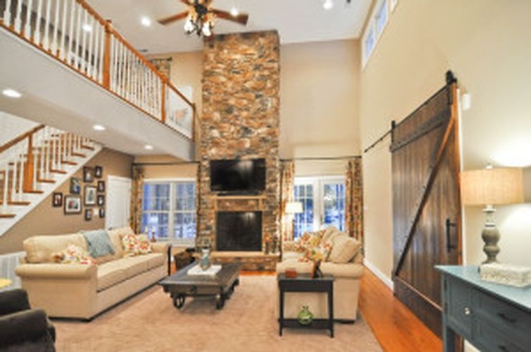 A living room with a stone fireplace and stairs
