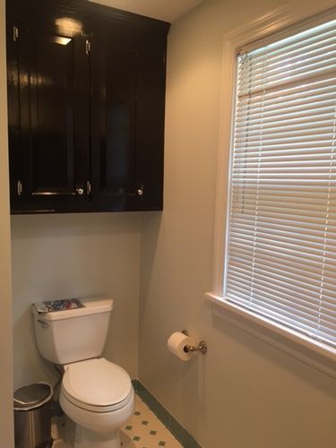 A bathroom with a toilet and a window with blinds.