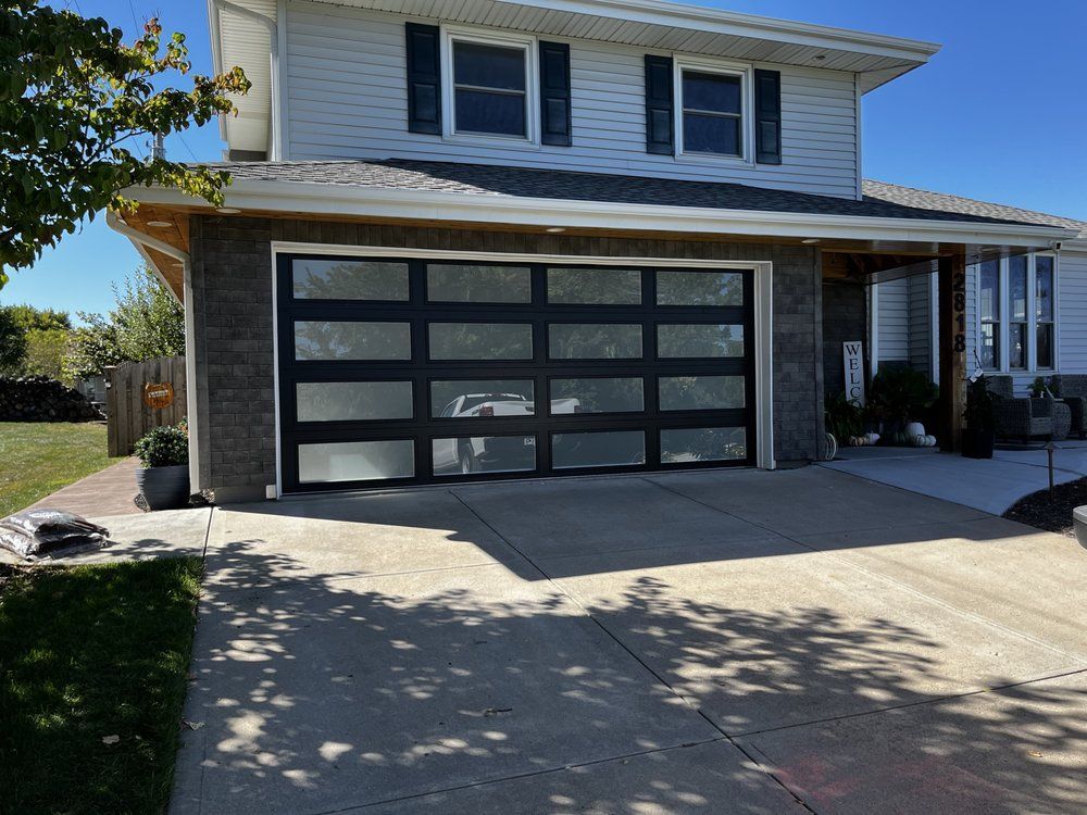 A large white house with a black garage door.