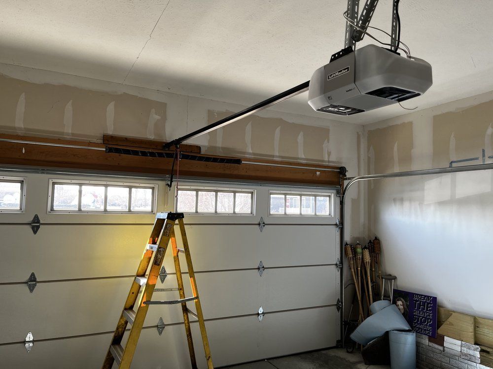 A garage with a ladder and a garage door opener.