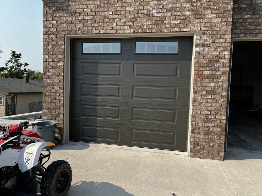 An atv is parked in front of a garage door