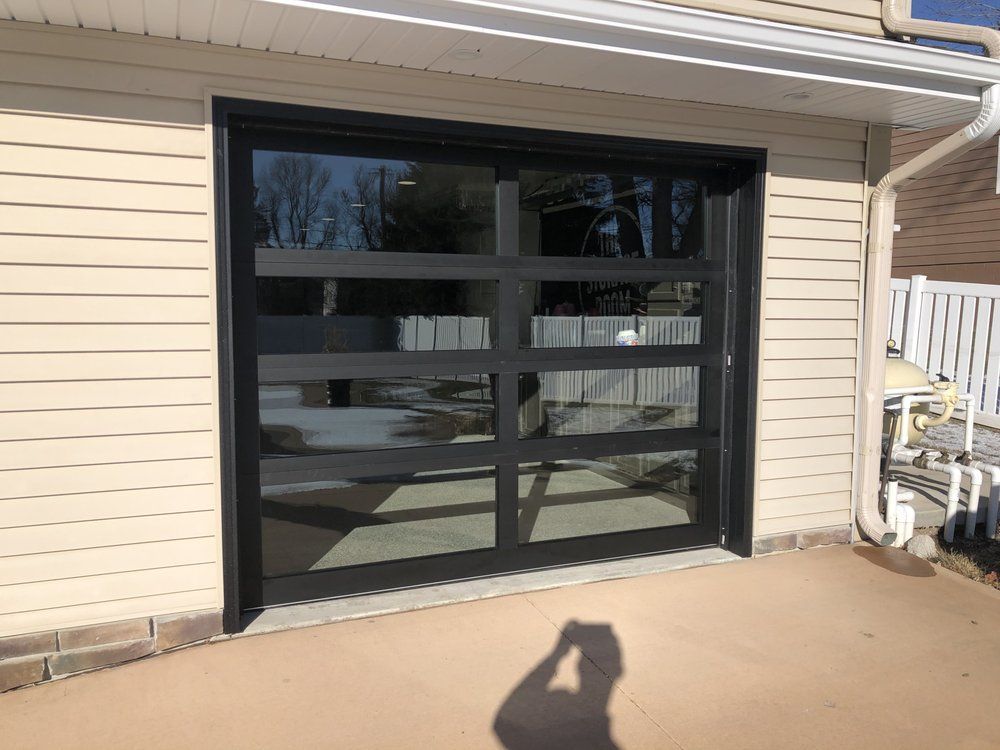 A garage door with a lot of windows is on the side of a house.