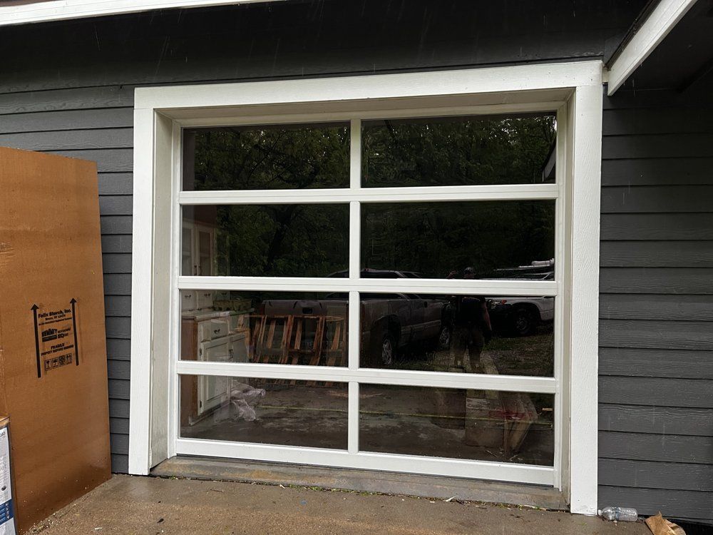 A white garage door is sitting on the side of a house.