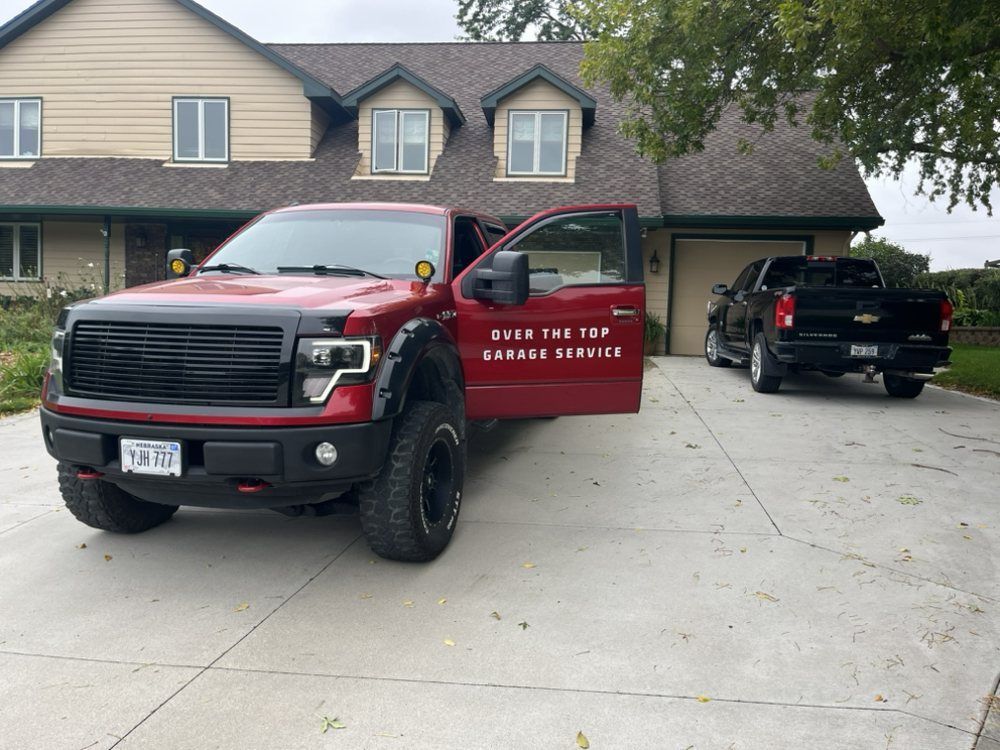 A red truck that says ever the top garage service is parked in front of a house
