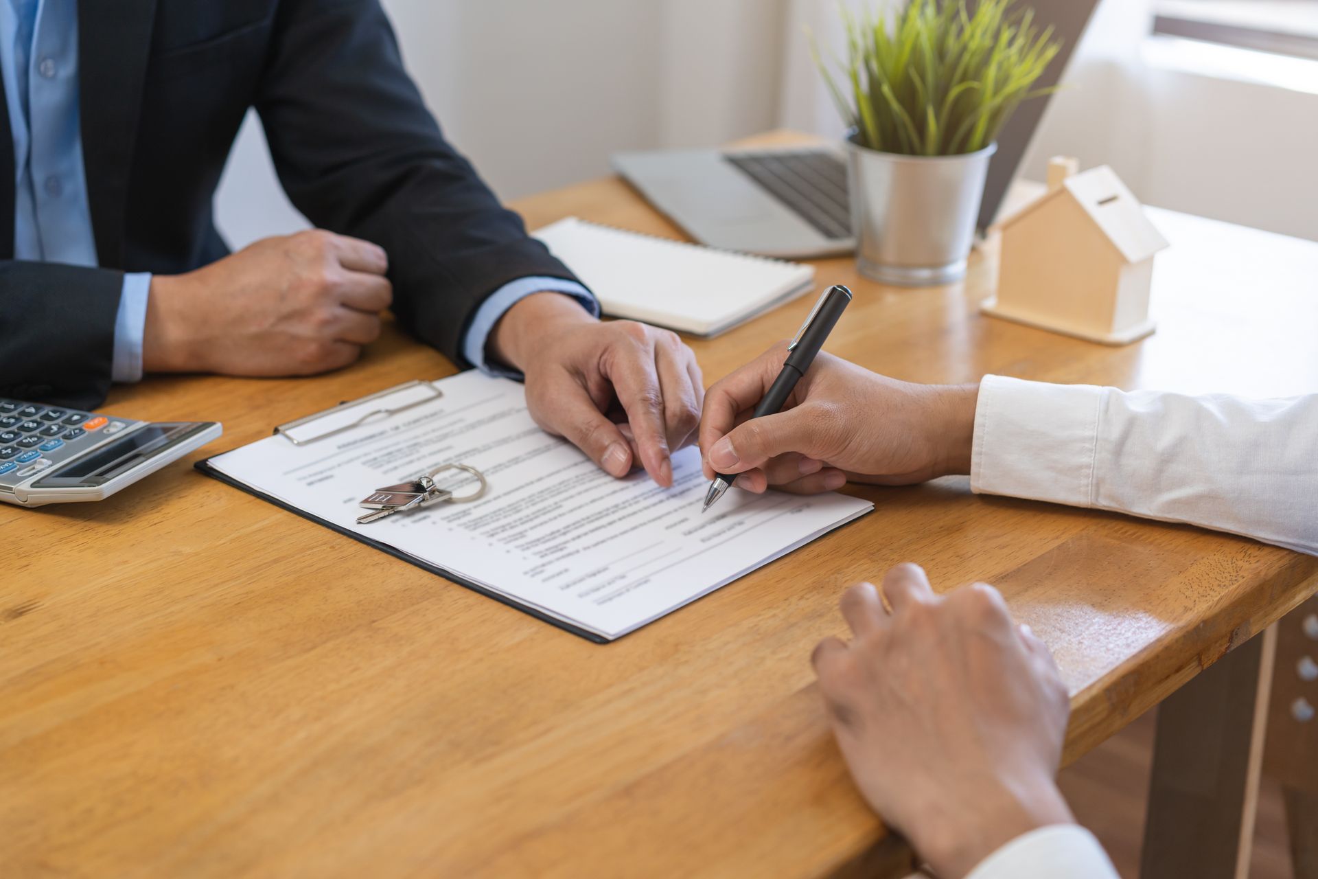 Client signing home contract, showcasing realtor companies guiding rental and purchase agreements.