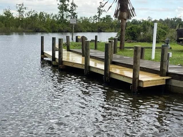 a man is working on a wooden deck with a red tool