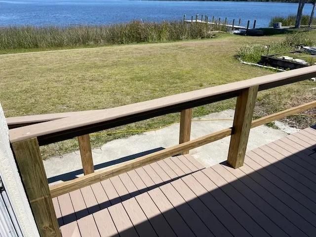 a deck with a table and benches surrounded by trees