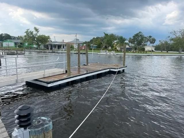 a man is working on a wooden deck with a red tool