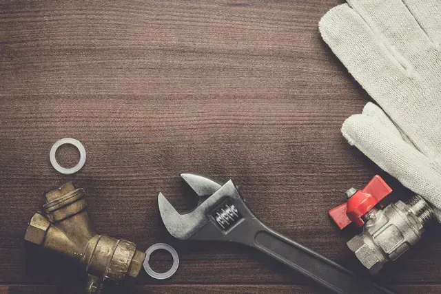Close-up of plumbing tools on wood, highlighting plumbing services, ready for repairs.