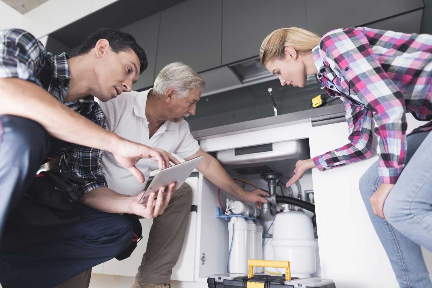 A woman shows plumbers a broken kitchen sink in Kalamazoo, MI by Roto-Rooter of Southwest Michigan y
