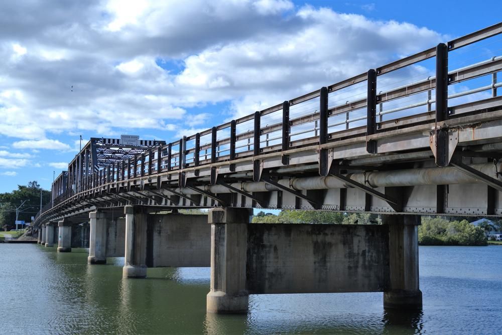 A Bridge Over a Body of Water on A Cloudy Day — Coffs Coast Plumbing in Macksville, NSW