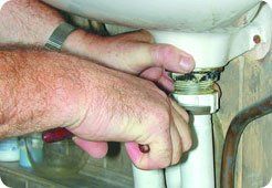 Unblocking of drains - South East London - The Considerate Plumber - plumber repairing sink pipe