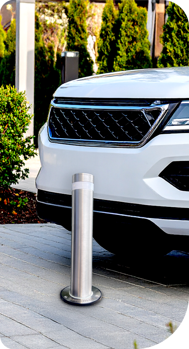 A white suv is parked next to a stainless steel pole.
