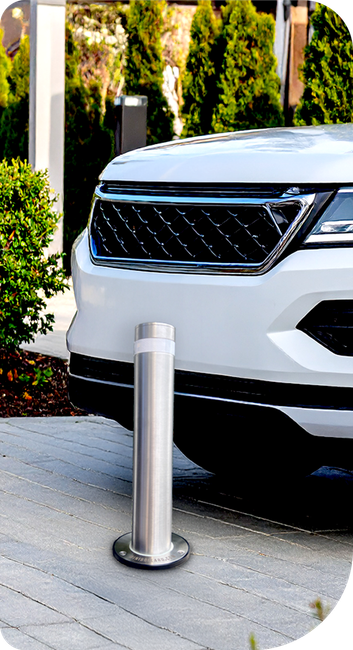 A white suv is parked next to a stainless steel pole.