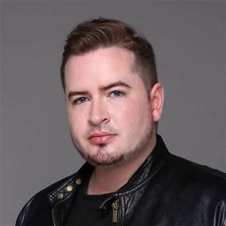 A man with a beard is wearing a black leather jacket.