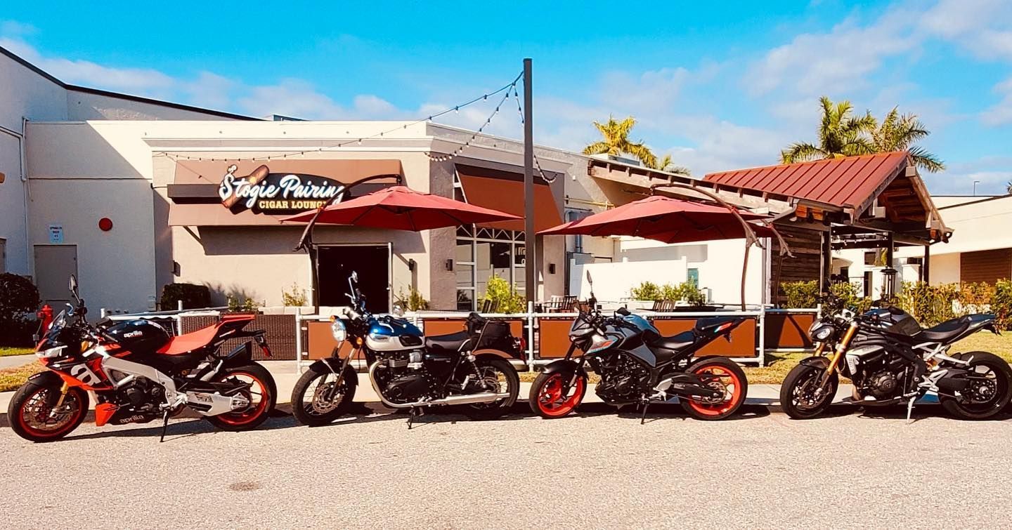 A row of motorcycles parked in front of a restaurant.