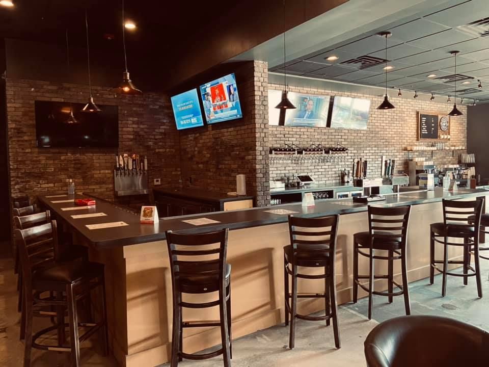 A restaurant with a long bar and chairs.