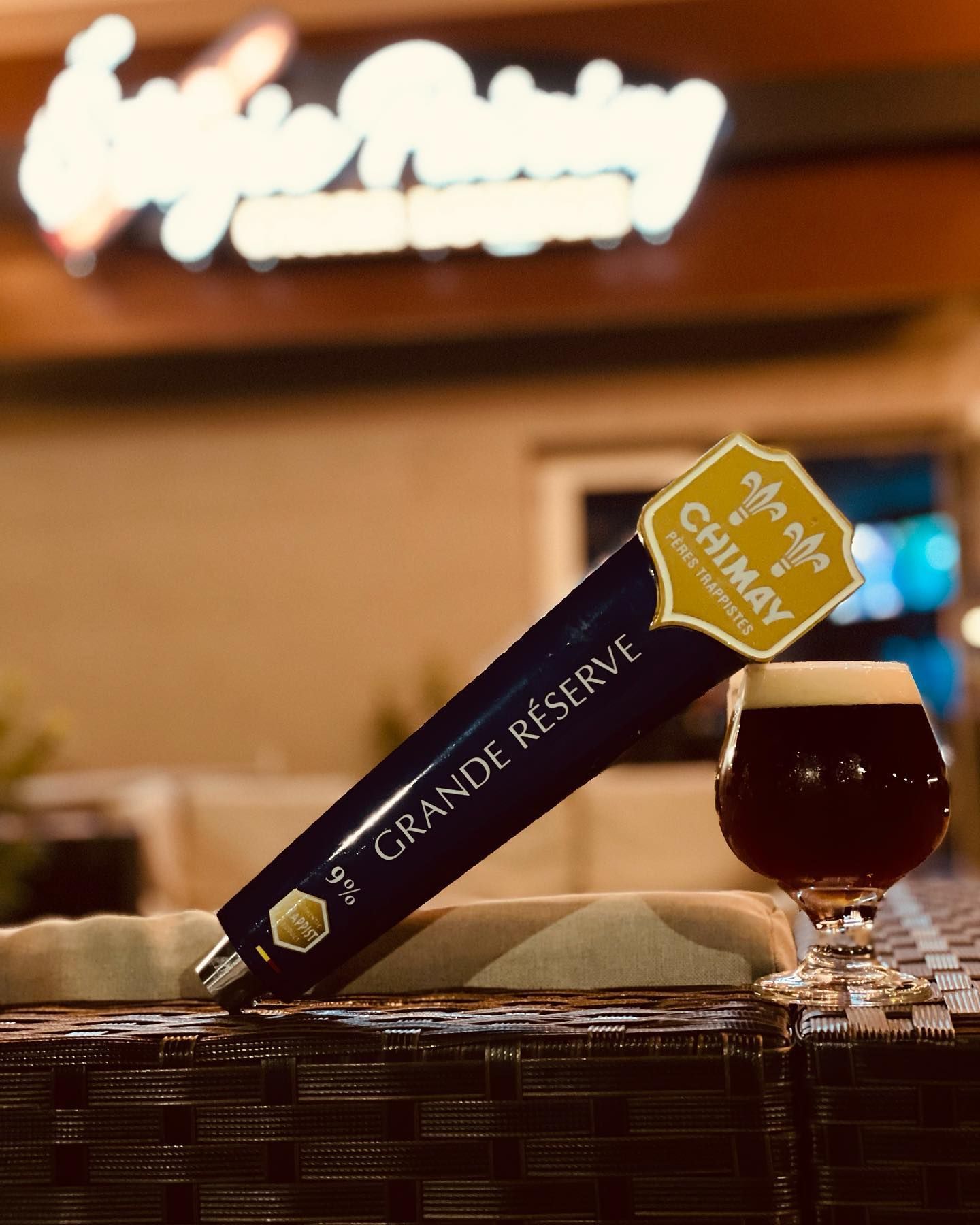 A beer tap that says grande reserve next to a glass of beer