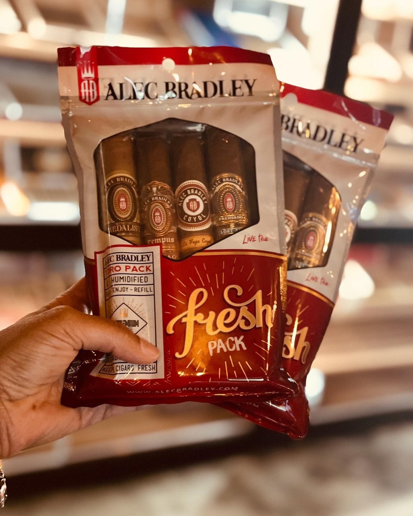 A person is holding a bag of cigars in their hand.