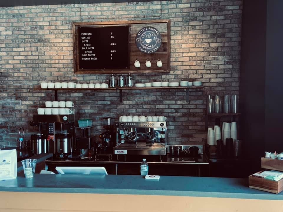A brick wall is behind a counter in a coffee shop