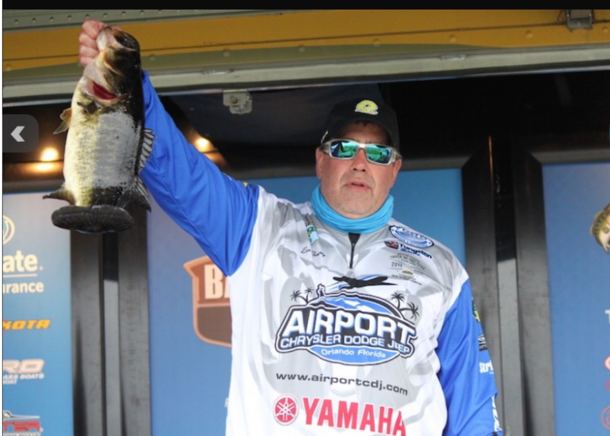 A man holding a fish wearing an airport yamaha shirt