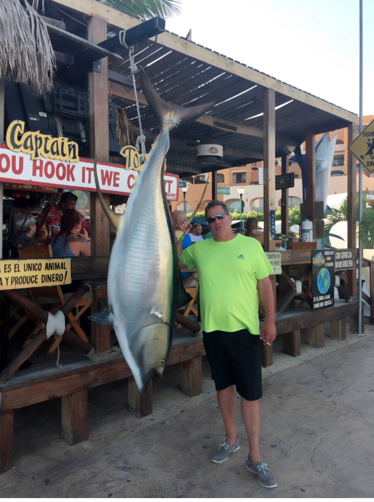 A man stands in front of a captain du hook it we c sign