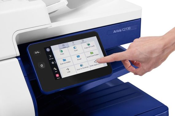 A person's finger touching a touchscreen on a Xerox printer, white and blue, showcasing its menu options.