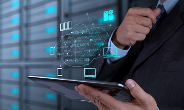 Man in suit holding tablet with glowing digital cloud graphic. Server racks in background.
