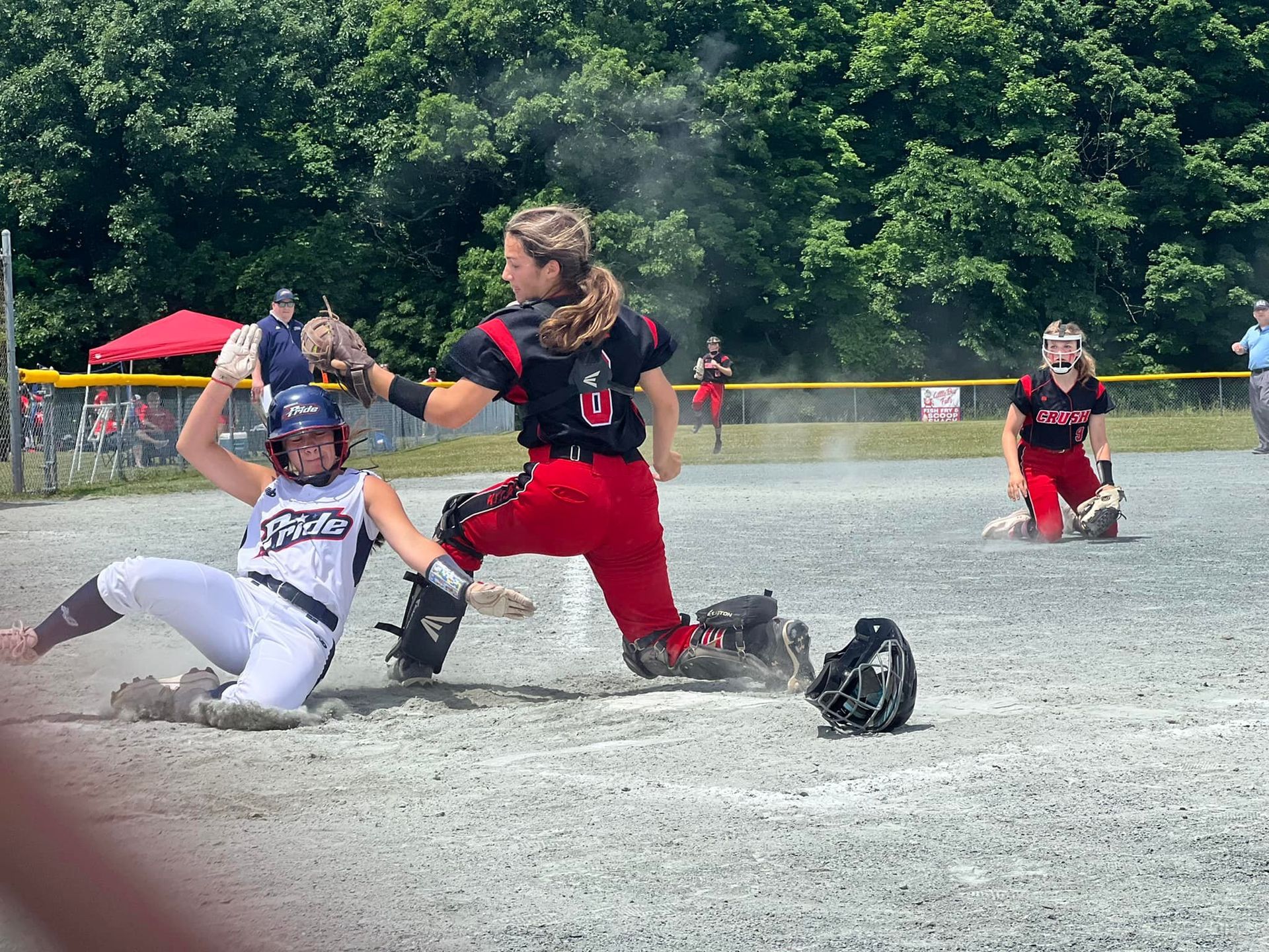 A girl is sliding into base during a softball game
