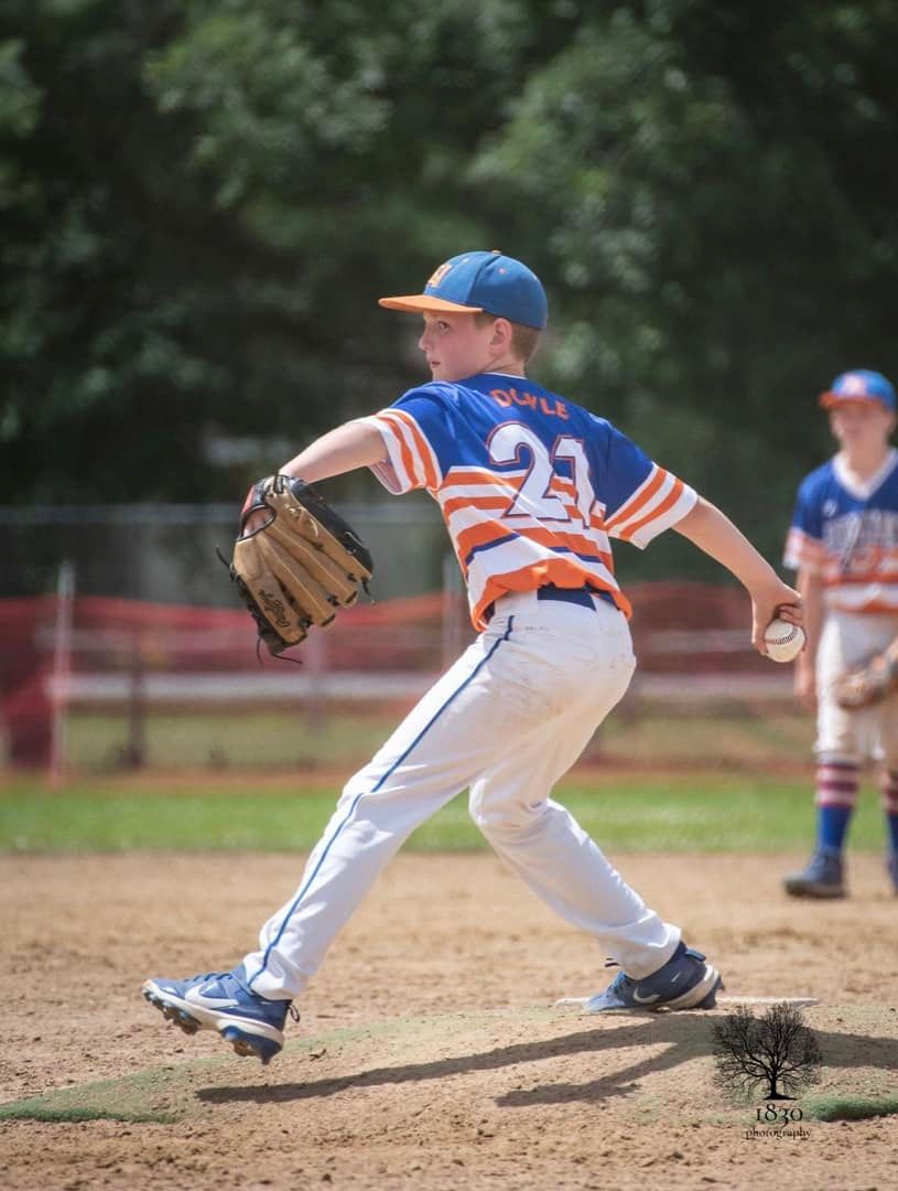A young boy is pitching a baseball on a field.