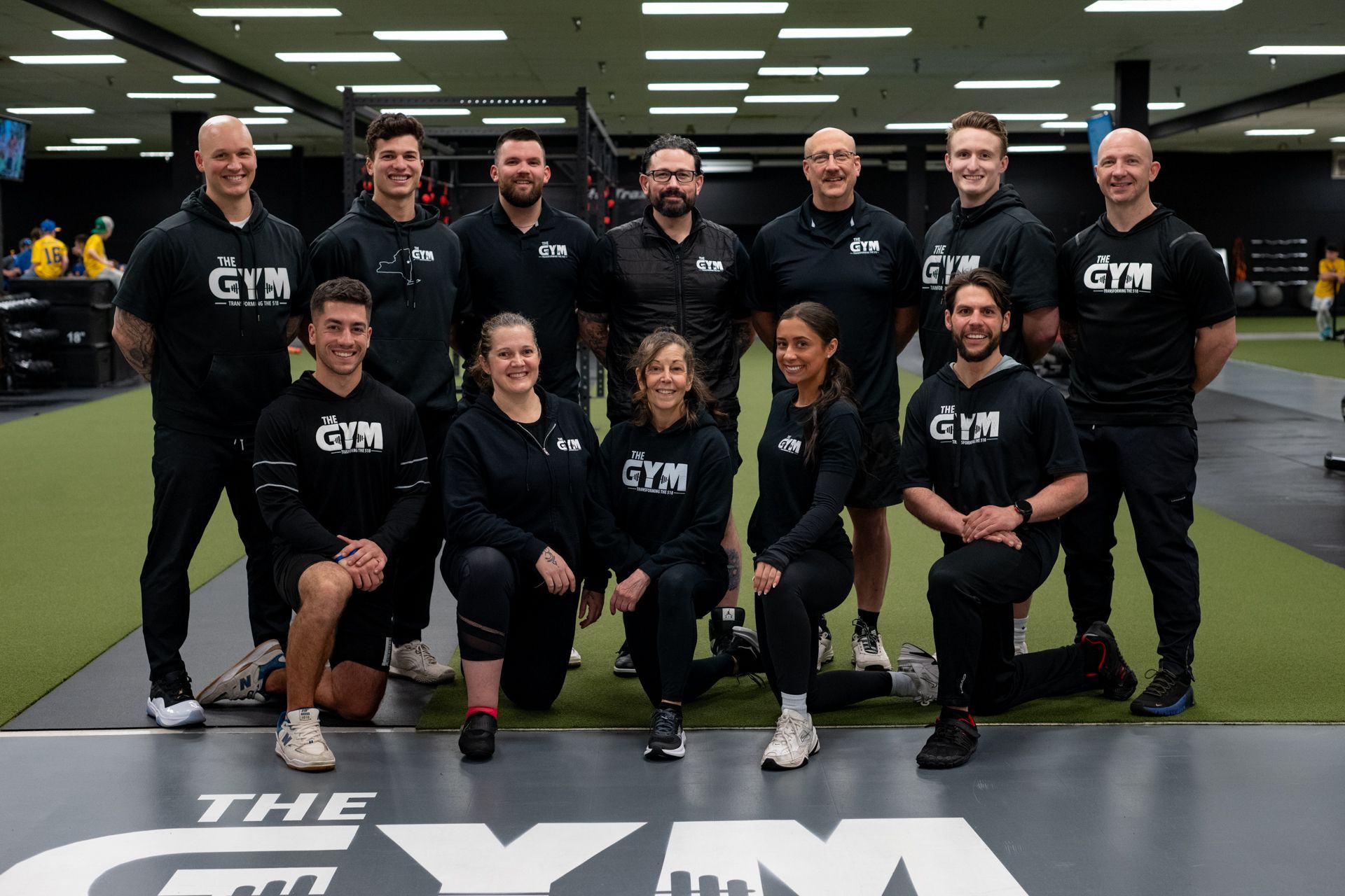 A group of people are posing for a picture in a gym.