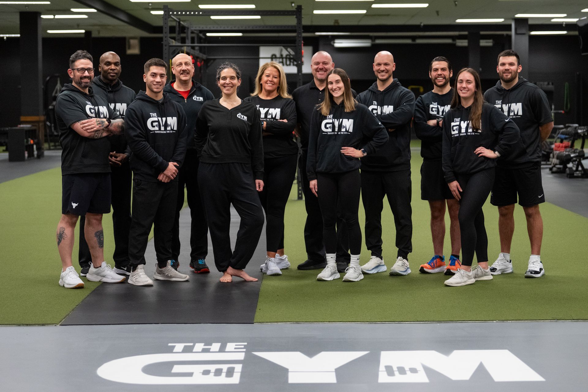 A group of people are posing for a picture in a gym.