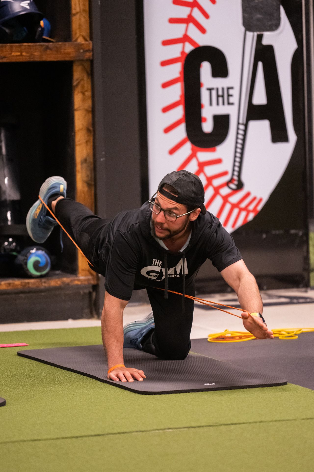 A man is doing exercises on a mat in front of a sign that says the ca