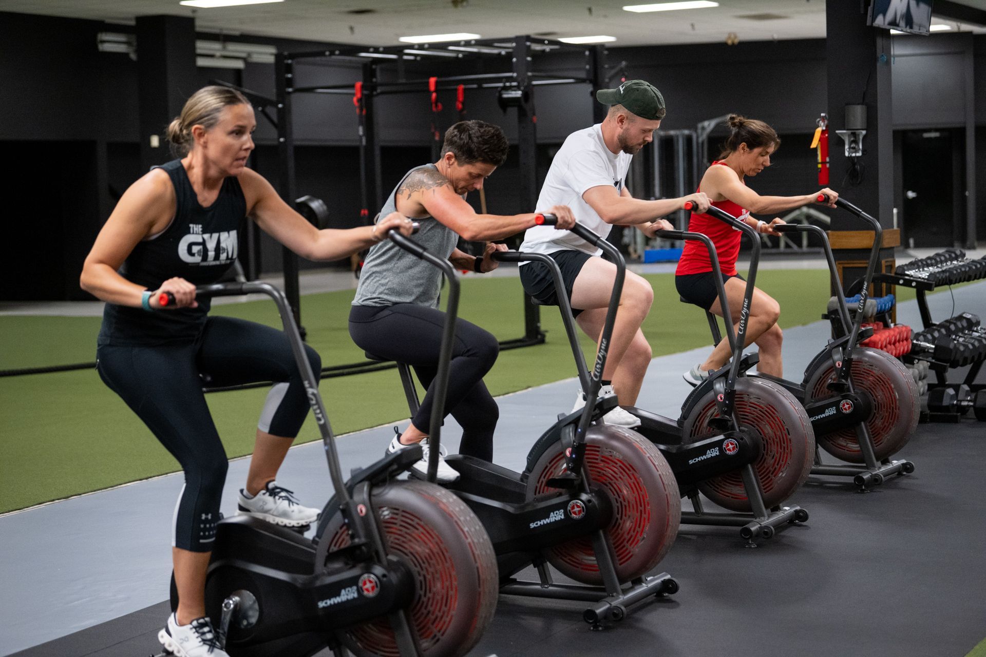 A group of people are riding exercise bikes in a gym.