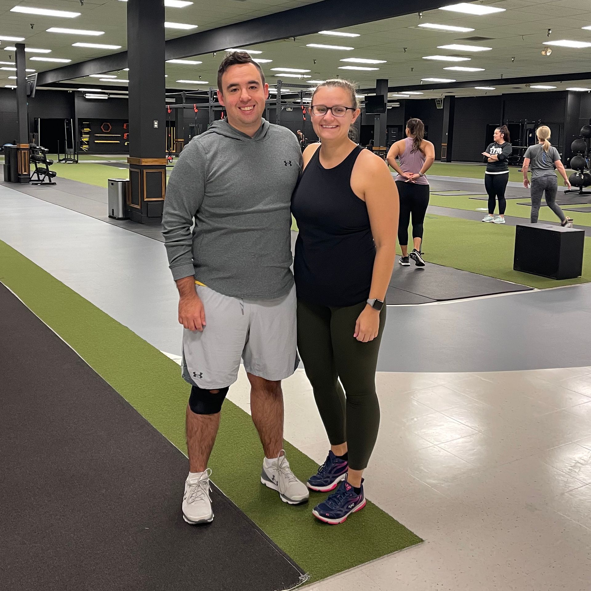 A man and a woman are posing for a picture in a gym