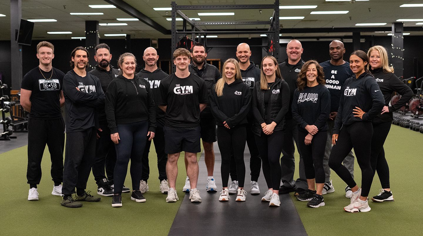 A group of people are posing for a picture in a gym.