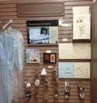 Display wall with various items: samples, jewelry, and a garment on a hanger.