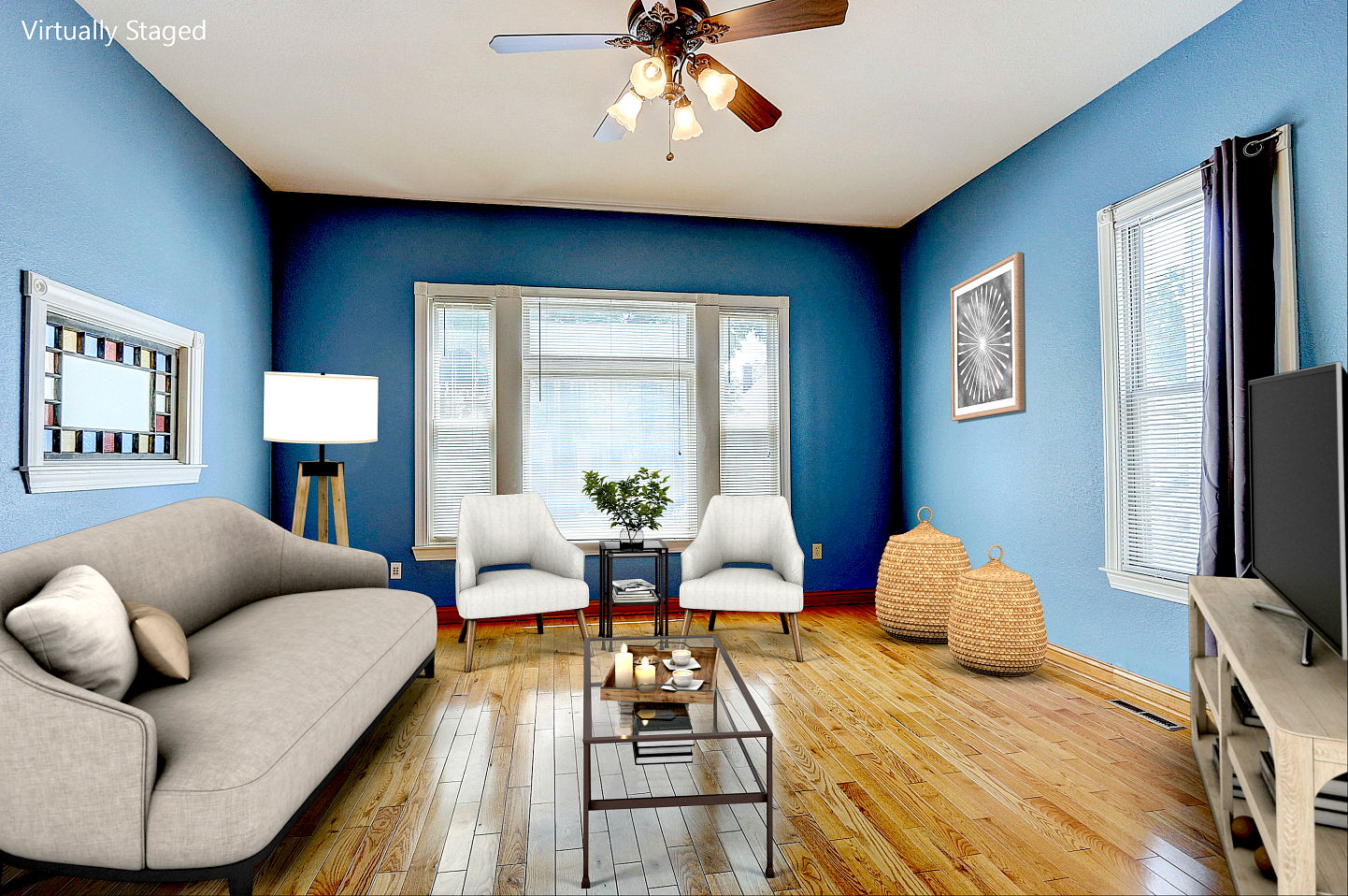 Blue-walled living room with light brown wood floor, light furniture, and a TV on a stand.