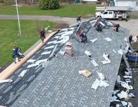 A group of people are working on the roof of a house.