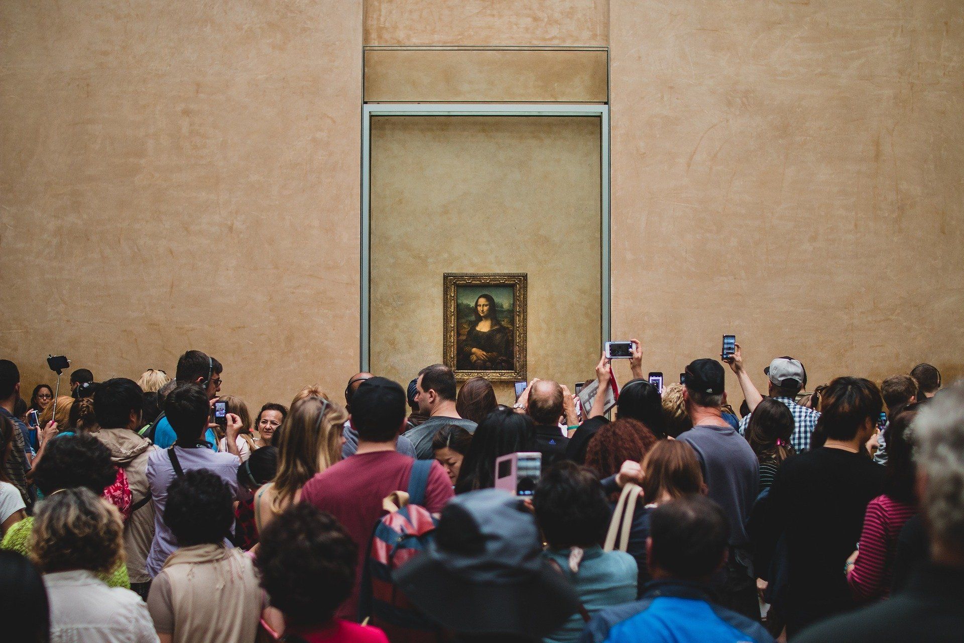 Een grote groep mensen verdringt zich bij de Mona Lisa in het Louvre om een foto te kunnen nemen