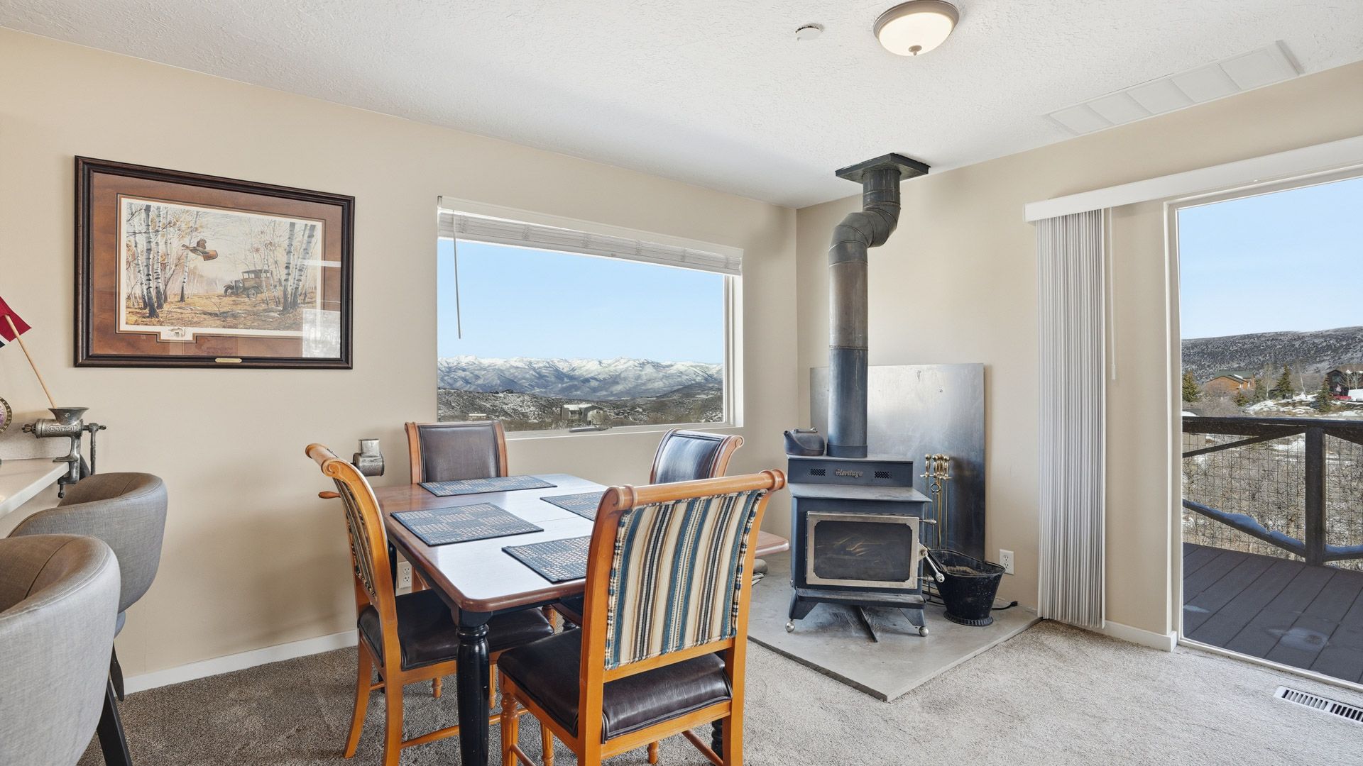 Main living room featuring architectural wood ceilings, a Heritage wood stove, and expansive mountain views.